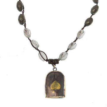 Elegant necklace featuring a gold leaf encased in a silver pendant, accented with clear and dark gray beads.
