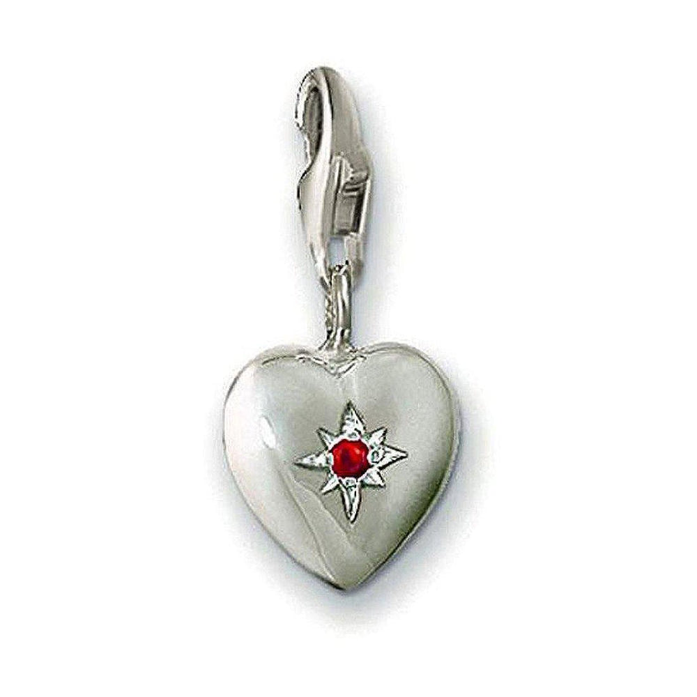 Silver heart charm with red crystal, featuring a starburst design.

