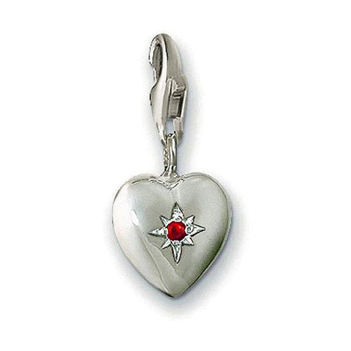Silver heart charm with red crystal, featuring a starburst design.

