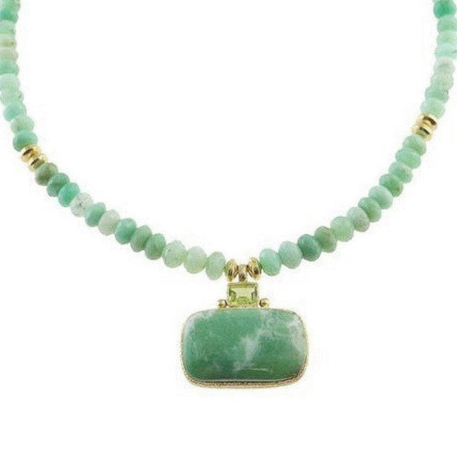 Necklace with green beads and a large green stone pendant on a white background