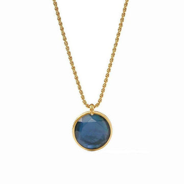 Gold rope chain necklace with a dark blue reversible statement pendant.
