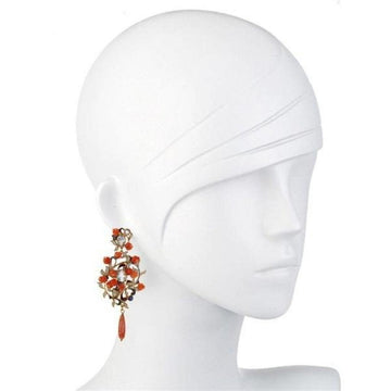 Elegant coral and rose gold drop earrings on a mannequin.
