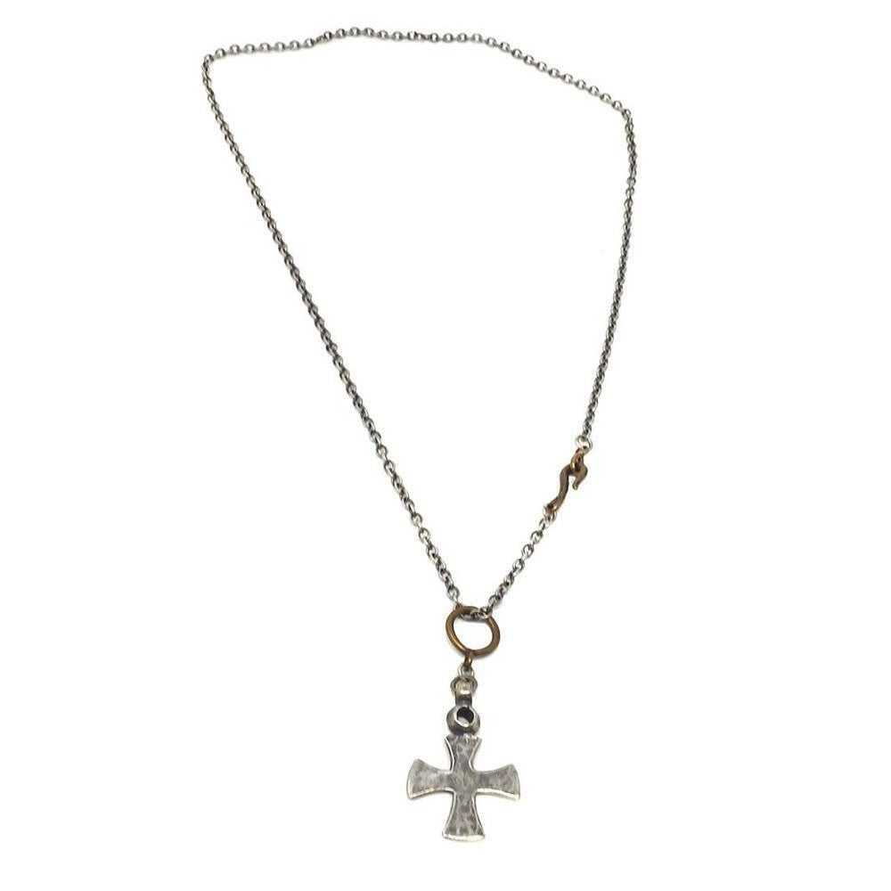 Silver cross necklace on a delicate chain with brass accents.

