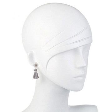 Gray tassel earrings with a daisy-shaped accent; shown on a mannequin.
