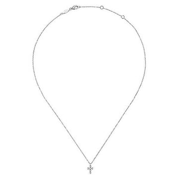 Dainty yellow gold necklace featuring a small diamond cross pendant.
