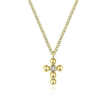 Delicate yellow gold cross necklace with a single diamond accent.
