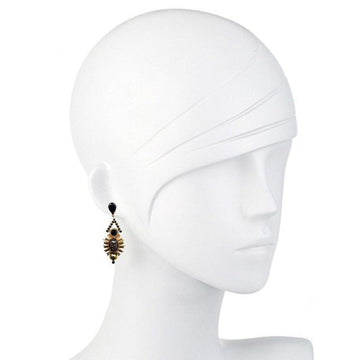 Black and gold drop earrings on a mannequin, showcasing intricate detailing.
