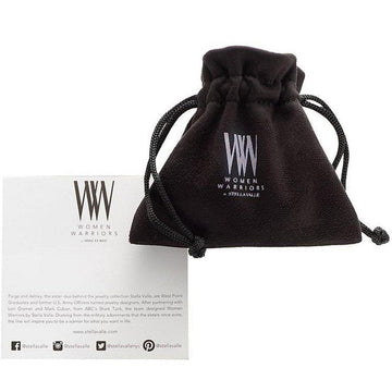 Black velvet jewelry pouch with a Women Warriors logo, next to a product information card.
