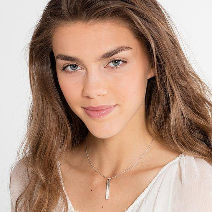 Silver bar pendant necklace on a model.
