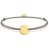 Engravable gold disc bracelet on beige cord
