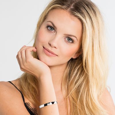 Woman's wrist wearing a sleek, engravable cuff bracelet.
