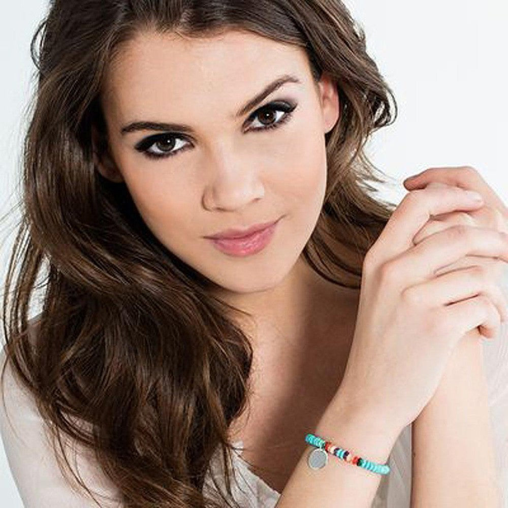 Woman's wrist wearing a colorful beaded bracelet with a silver charm.
