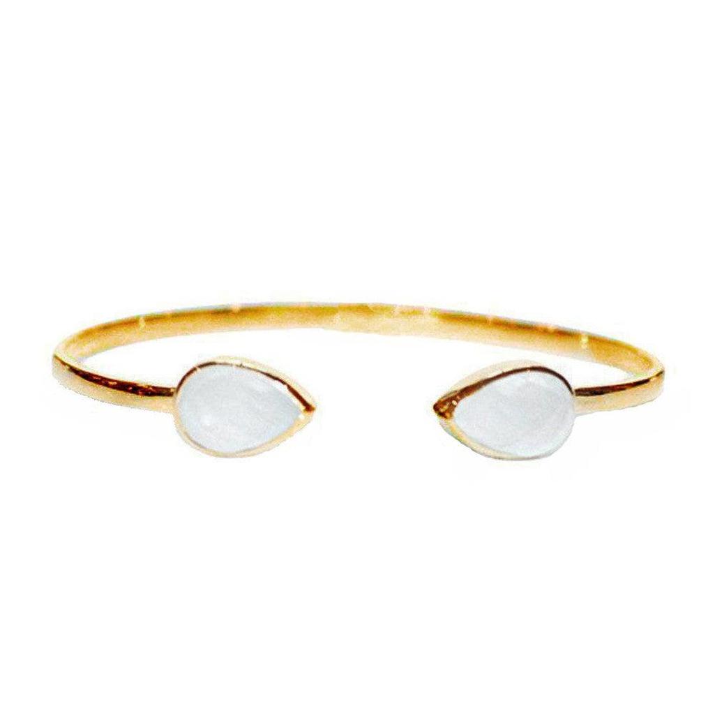 Gold cuff bracelet with two teardrop-shaped white stones.
