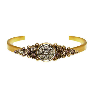 Fay Winged Cuff: Gold cuff bracelet featuring a central antique coin with a starburst design, accented with sparkling crystals.
