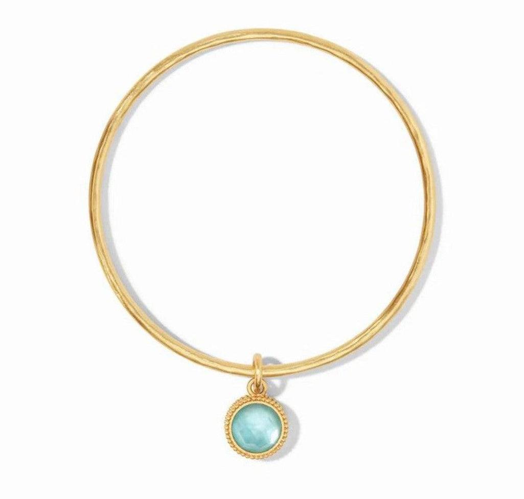Gold Fleur-de-Lis bangle with light blue gemstone charm
