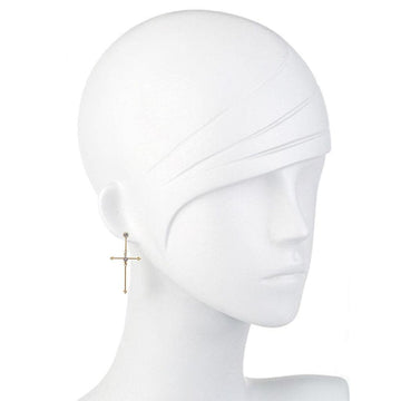 Gold cross earrings with small stones, shown on a mannequin.
