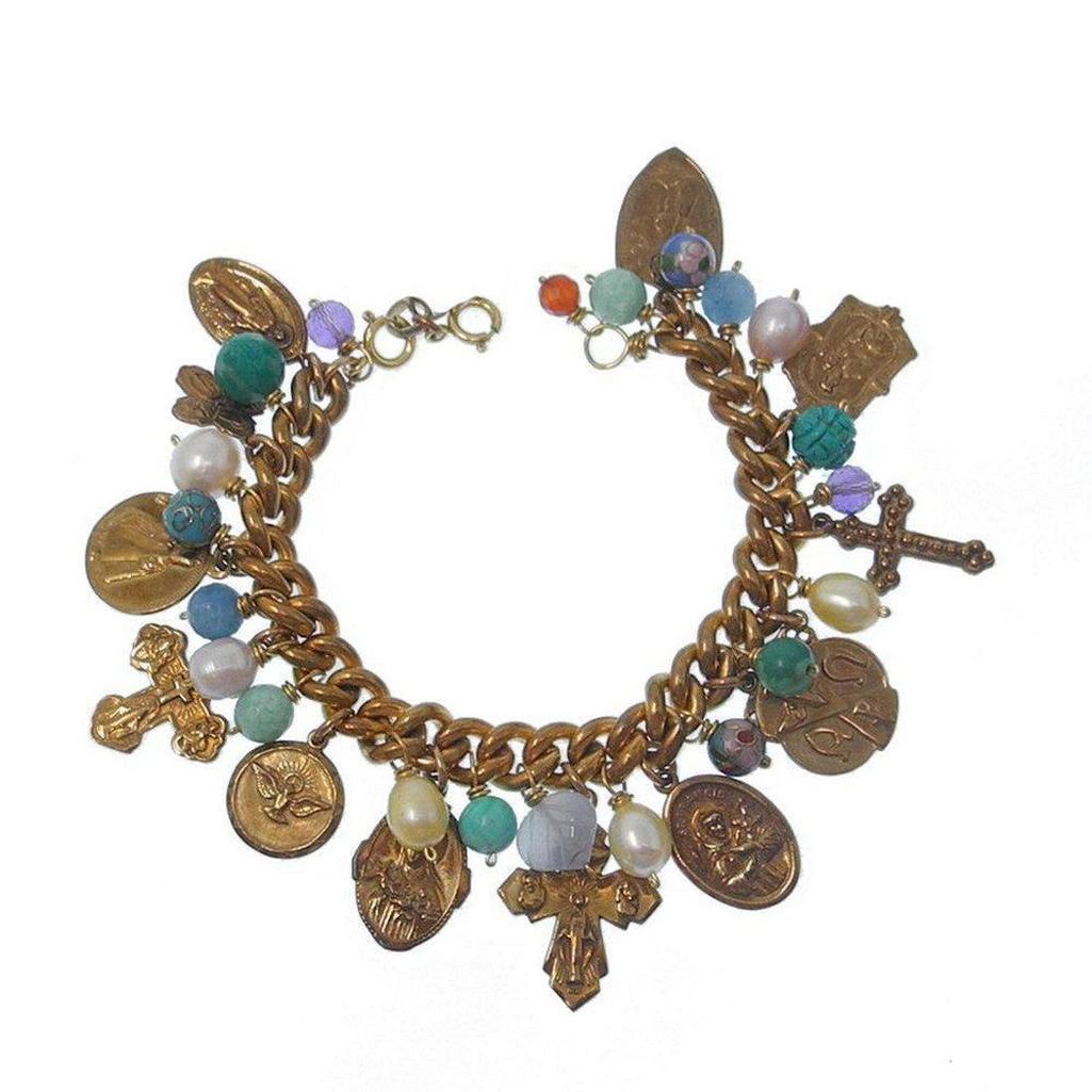 Gold charm bracelet with religious medallions, colorful beads, and pearls.
