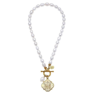 Elegant pearl necklace with gold coin pendant, featuring a detailed etched design.
