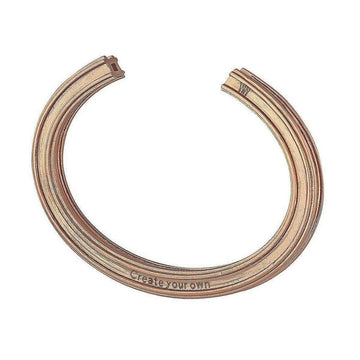 Rose gold customizable bangle bracelet with engraved "Create your own" detail.
