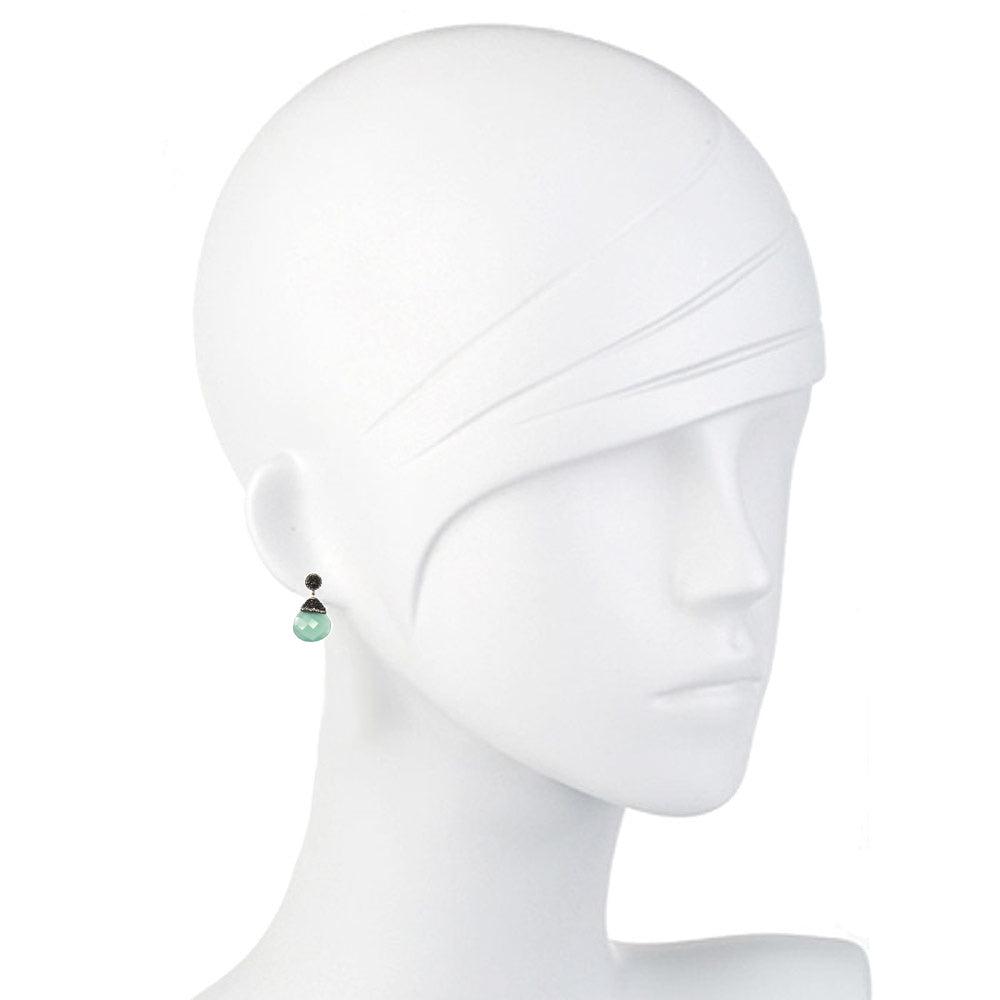 Elegant teardrop hematite earrings with a pale green stone, shown on a mannequin.
