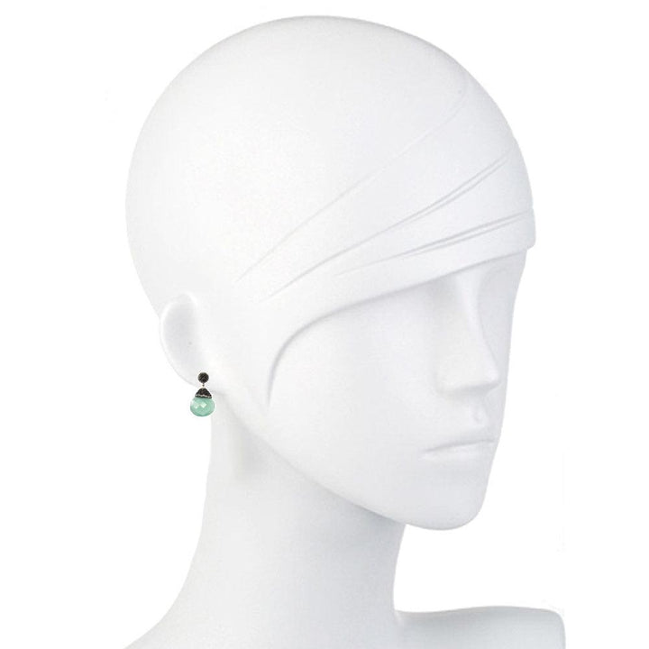 Elegant teardrop hematite earrings with a pale green stone, shown on a mannequin.
