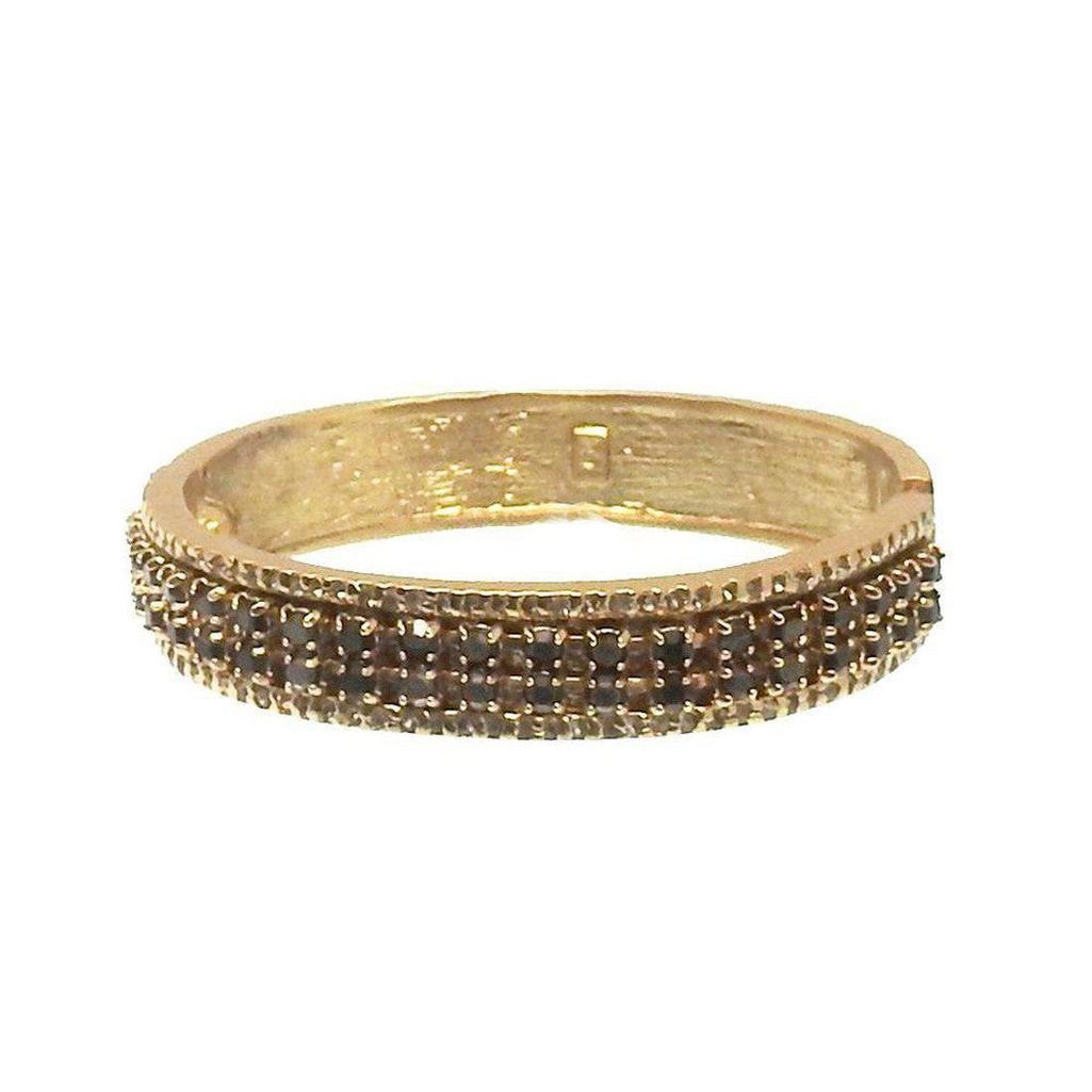 Gold hinged bangle bracelet with dark crystal accents.
