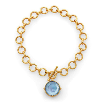 Gold chain necklace with a light blue gemstone pendant.
