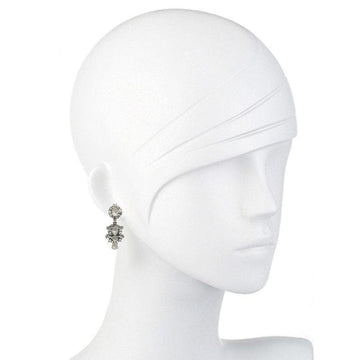 Elegant dangle earrings with shimmering stones on a mannequin.
