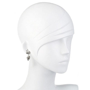 Elegant pearl drop earrings on a white mannequin, showcasing sparkling detail.
