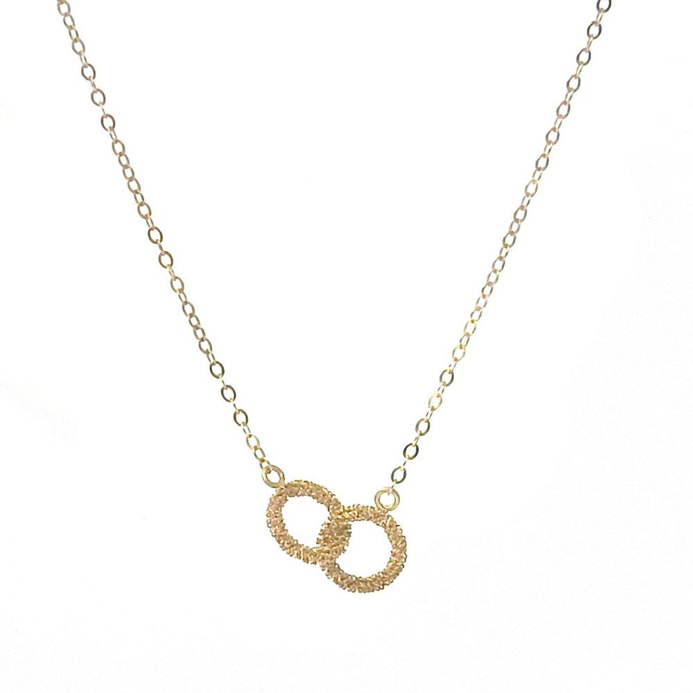 Gold infinity necklace with delicate chain and textured interlocking circles.
