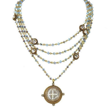Multi-strand iridescent blue crystal necklace with antique gold accents and a St. Jude medal pendant.
