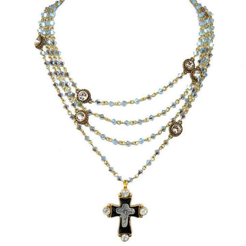 Multi-strand necklace featuring iridescent blue crystals, gold accents, and a black cross pendant.
