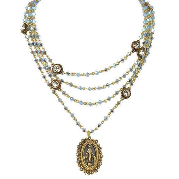 Layered iridescent blue crystal necklace with gold accents and Madonna medallion.
