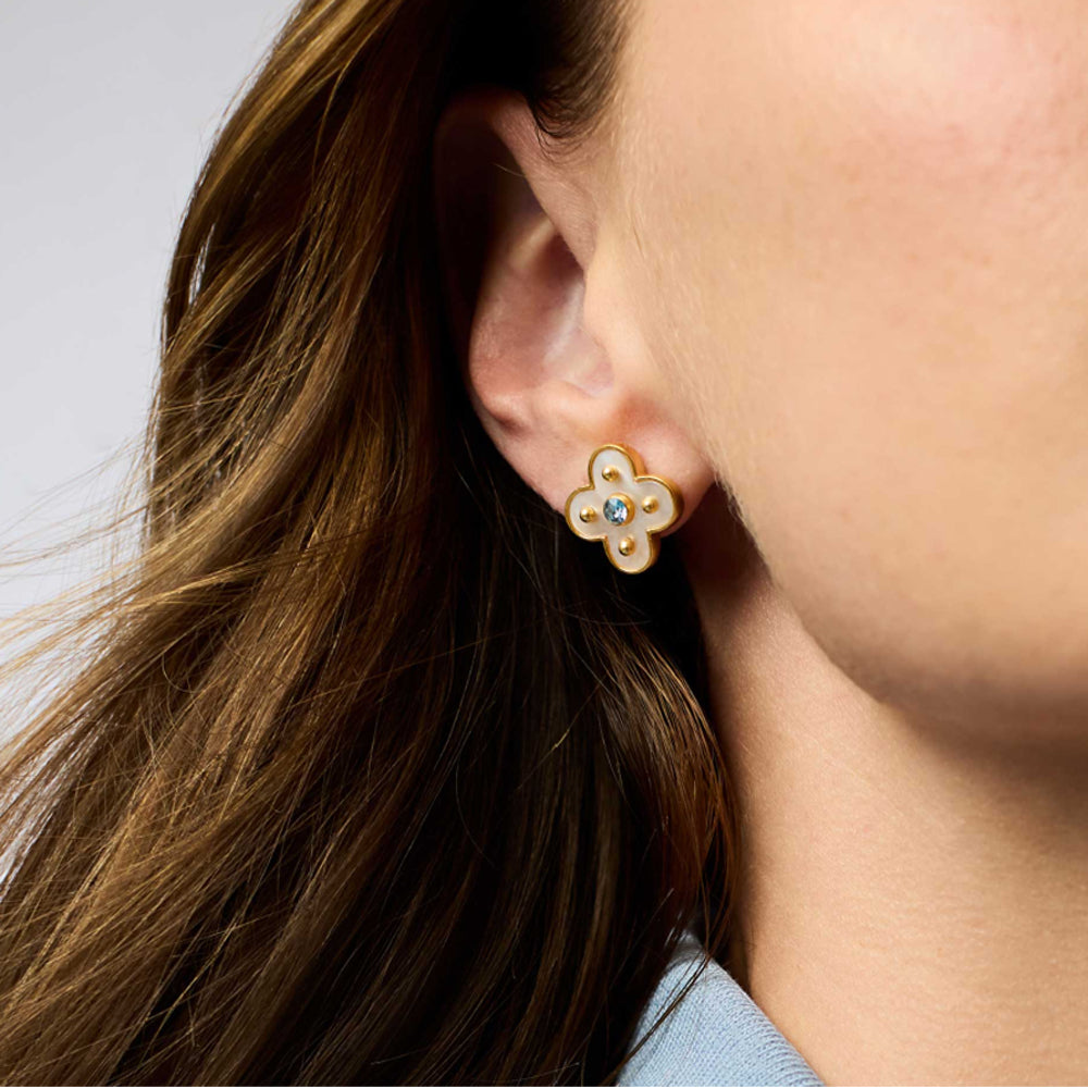 Colette stud earring in 24K gold plate with mother of pearl and a central CZ stone worn on an earlobe.