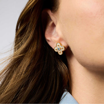 Colette stud earring in 24K gold plate with mother of pearl and a central CZ stone worn on an earlobe.