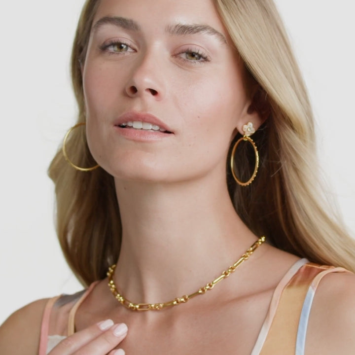 Model wearing a 24K gold-plated Colette statement necklace with link chain and mother of pearl pendant.