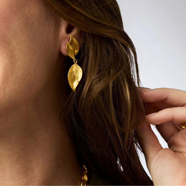 Julie Vos Willow Midi earrings featuring two hammered 24K gold-plated leaf charms worn on a pierced ear.