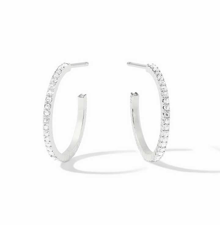 A pair of silver hoop earrings with a row of clear pavé-set stones, displayed on a clean white background with soft shadows.