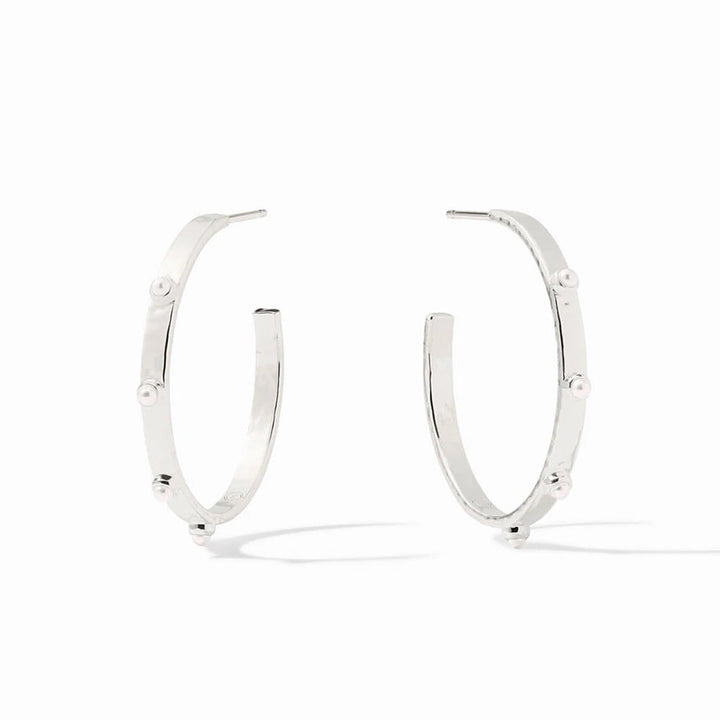 A pair of polished silver hoop earrings with small, evenly spaced round pearl-like beads set along the front, displayed on a clean white background.