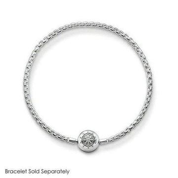 Silver charm featuring an ornate design, shown on a delicate chain bracelet (bracelet sold separately).
