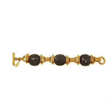 Gold tone bracelet featuring three dark grey labradorite stones.
