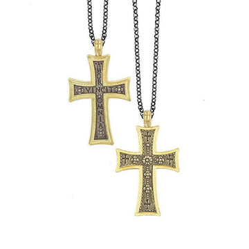 Ornate gold and dark metal cross pendants on black chains; one features an inscription.
