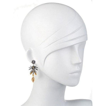 Mixed-metal leaf-shaped dangle earrings on a mannequin.
