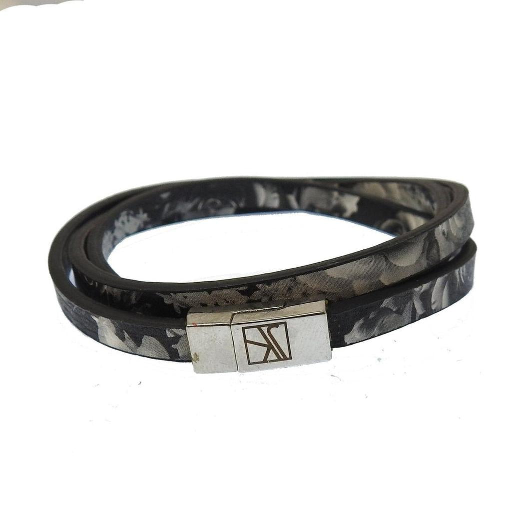 Black leather wrap bracelet with floral print and silver clasp.
