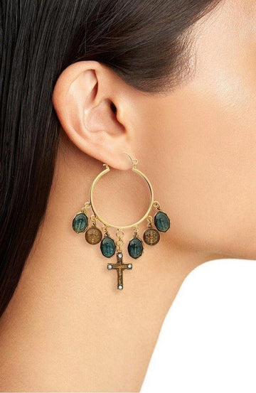 Gold hoop earrings adorned with dark green and gold charms, and a small cross pendant.
