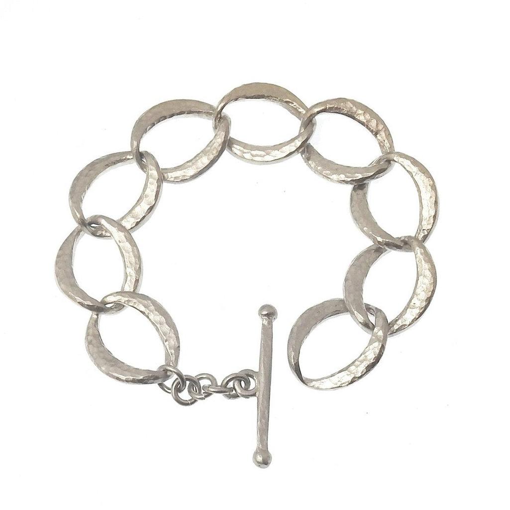 Silver link bracelet with hammered texture and toggle clasp.
