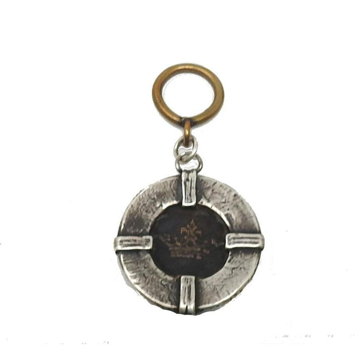 Circular statement coin pendant; dark metal center with gold crown design, silver-toned outer ring, brass loop.
