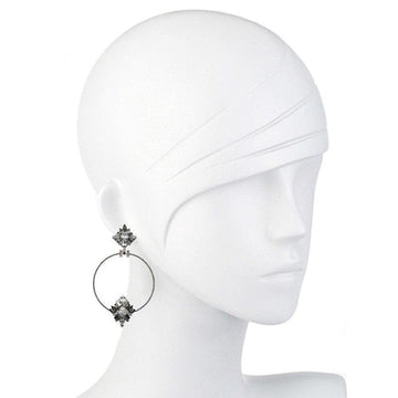 Silver hoop earrings adorned with sparkling crystal accents, shown on a mannequin.
