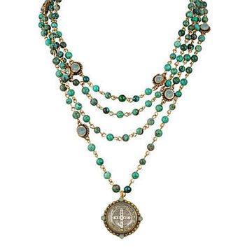 Multi-strand turquoise bead necklace with antique coin pendant.

