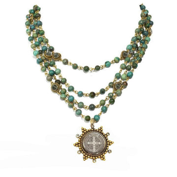 Three-strand turquoise bead necklace with gold accents and a detailed medal pendant.
